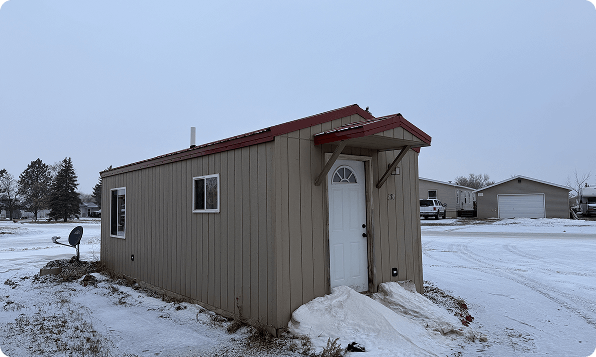 Small manufactured home in a snowy residential community