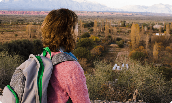 Woman with a backpack overlooking a scenic mountain valley
